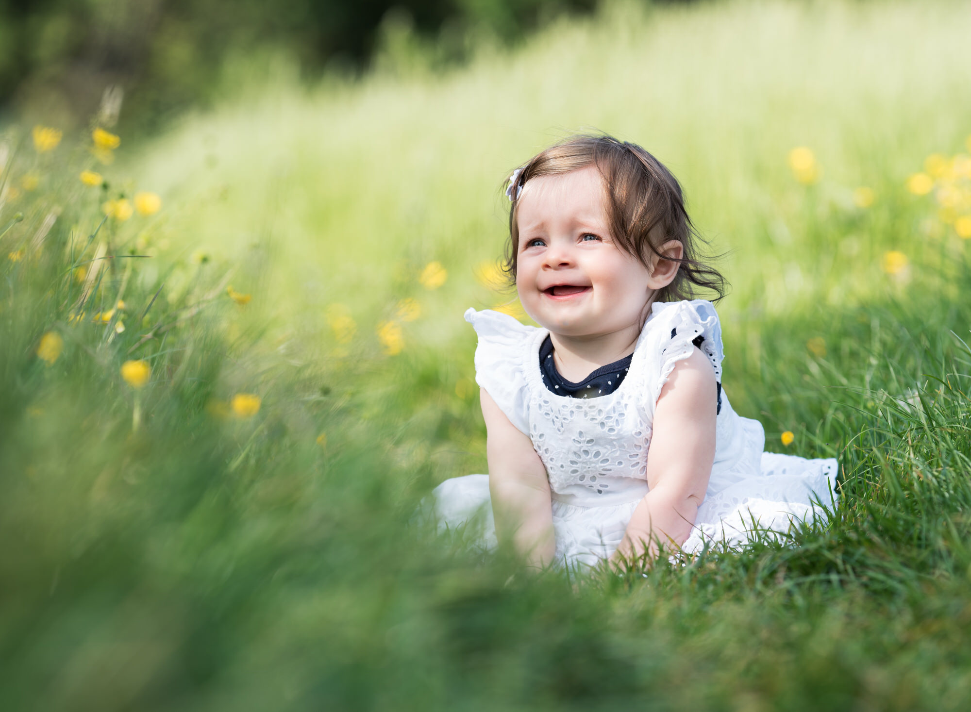 Baby smiling in buttercup meadow during spring photoshoot in Wallingford