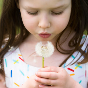 Girl blowing a dandelion during a Spring photoshoot in Wallingford