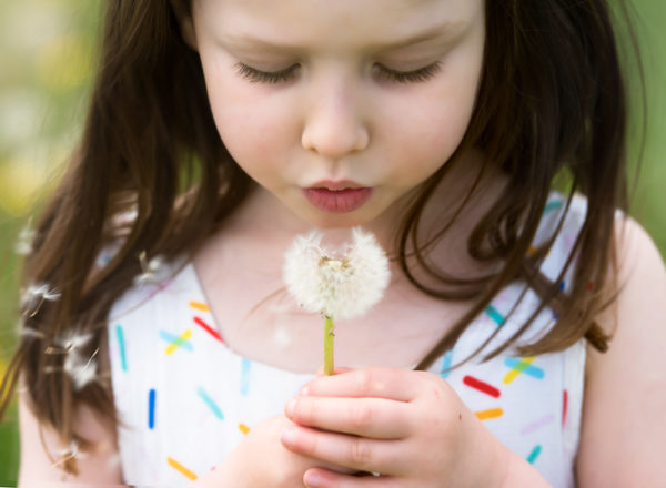 Girl blowing a dandelion during a Spring photoshoot in Wallingford