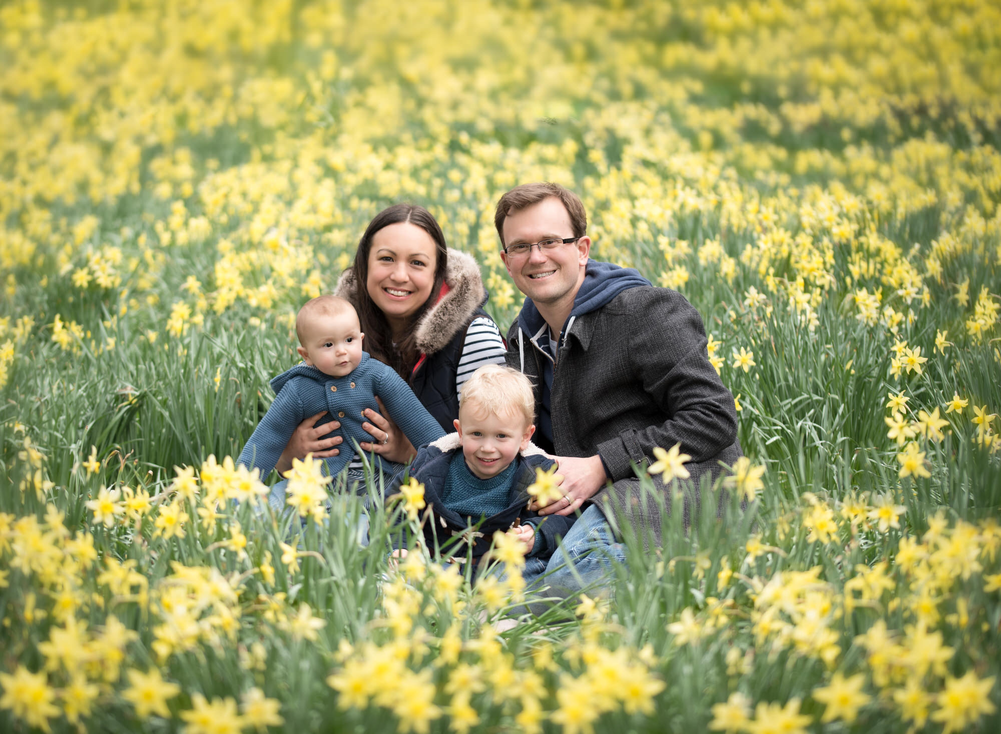 Family sitting amongst the daffodils during spring photoshoot in Wallingford