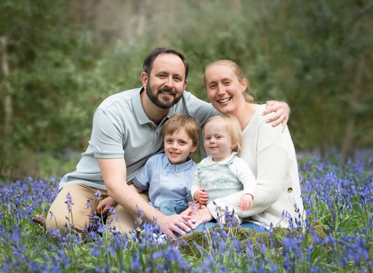 Family smiling in bed of bluebells during wallingford photoshoot